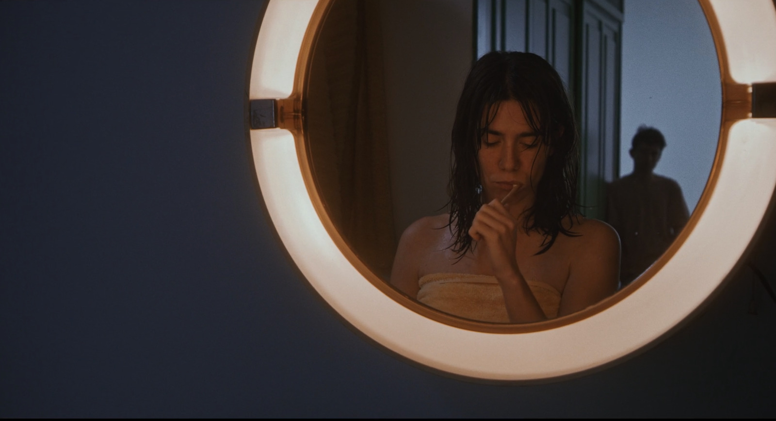 a woman standing in front of a mirror brushing her teeth