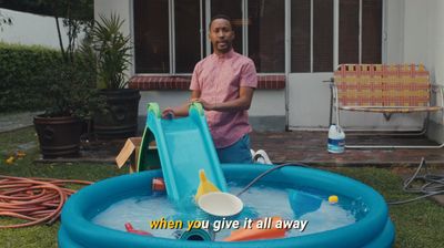 a man standing next to a pool with a slide in it