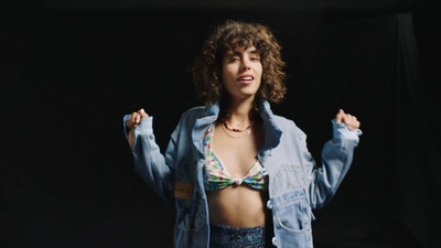 a woman with curly hair wearing a jean jacket