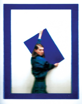 a woman holding a blue square in her hands