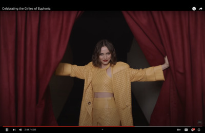 a woman standing in front of a red curtain