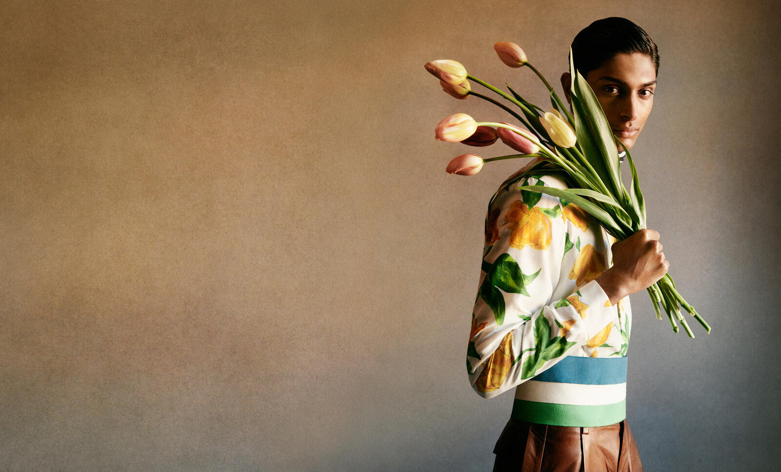 a man holding a bunch of flowers in his hands