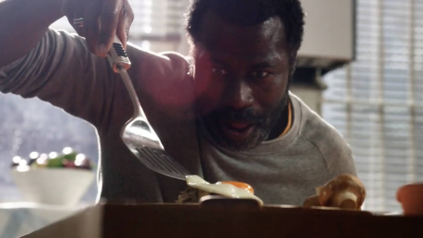 a man holding a knife and fork over a box of food