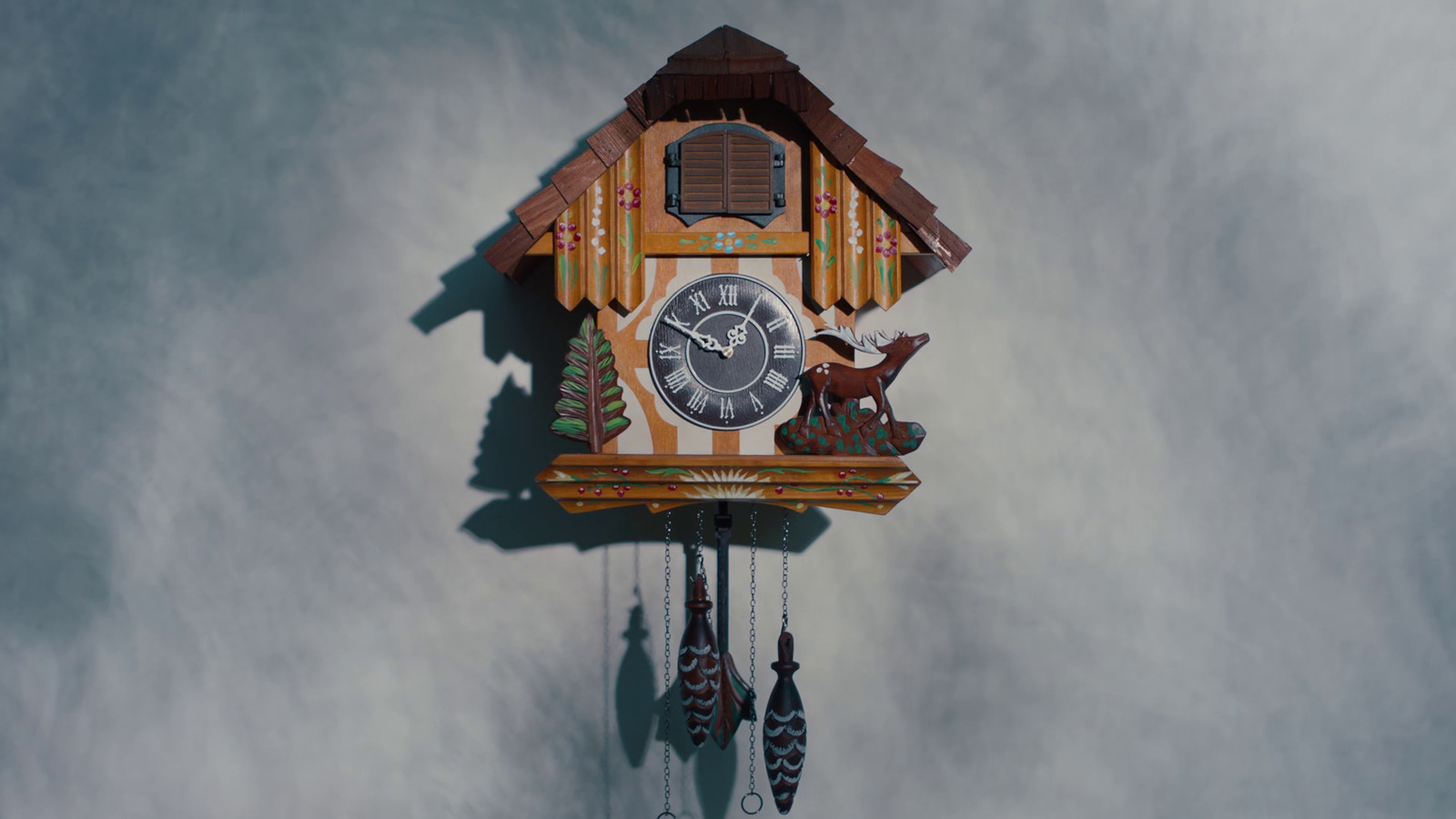 a wooden cuckoo clock with a deer on it's face