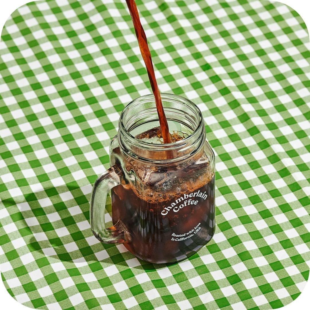 a glass jar filled with liquid sitting on top of a green and white checkered