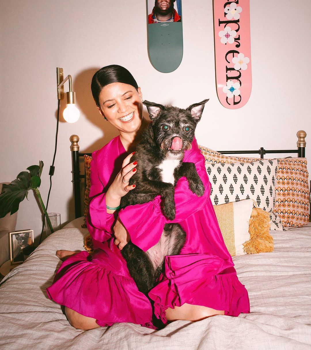 a woman sitting on a bed holding a cat