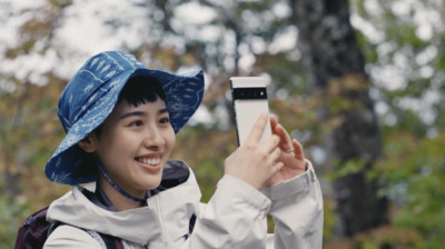 a woman in a blue hat taking a picture with her cell phone