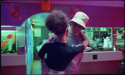 a man and a young boy standing in front of a fish tank