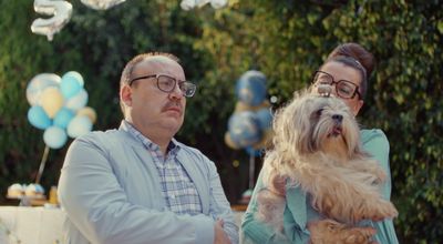 a man and a woman standing next to a dog