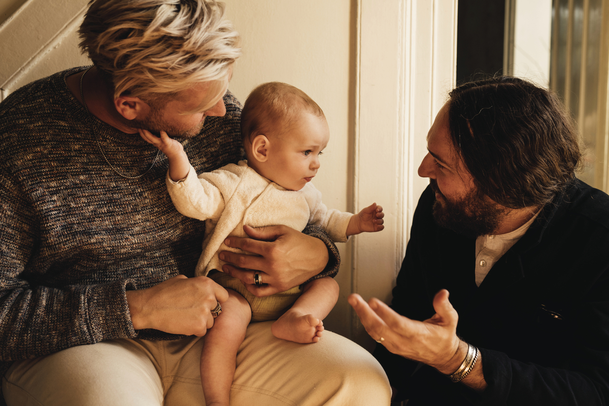 a man holding a baby next to a woman