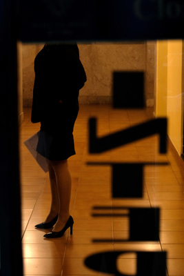 a woman standing in front of a window with a black umbrella