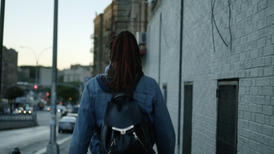 a person with dreadlocks walking down the street