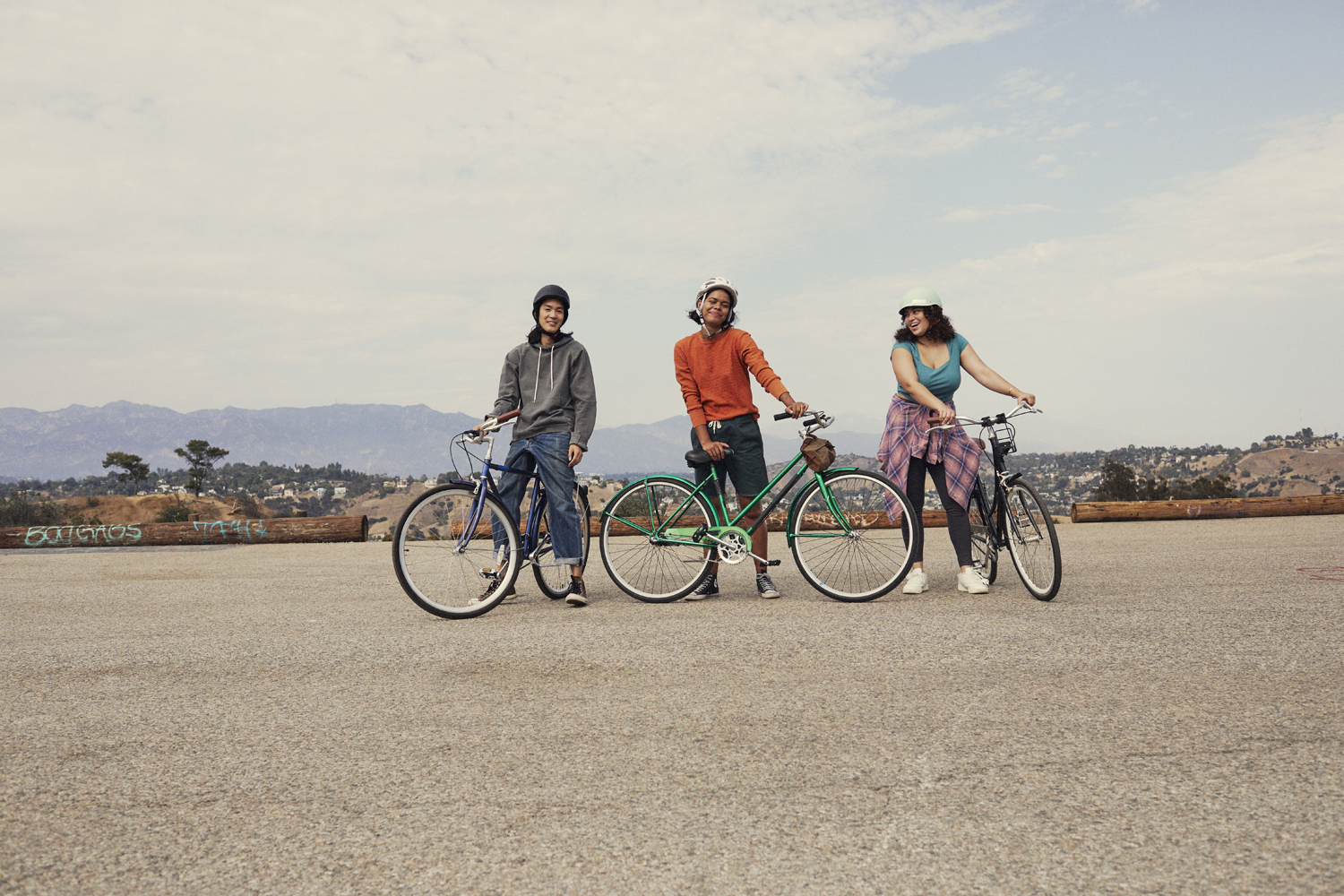 a group of three people standing next to each other on bikes