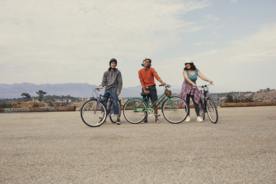 a group of three people standing next to each other on bikes