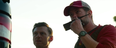 two men standing next to each other near a truck