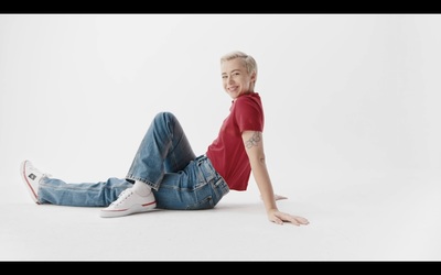 a man in a red shirt and jeans laying on the ground