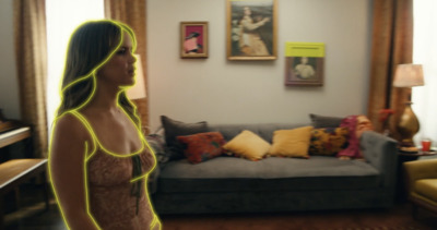 a woman standing in a living room next to a couch