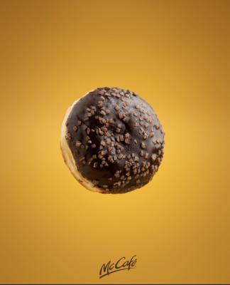 a donut with chocolate sprinkles on a yellow background