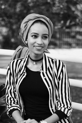 a woman sitting on a bench wearing a turban