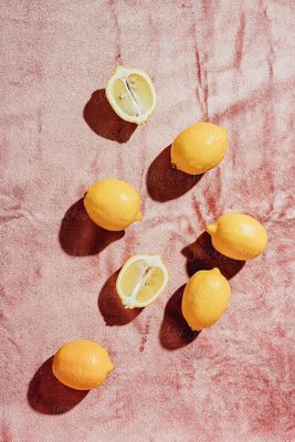 a group of lemons sitting on top of a pink surface