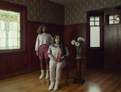 two women sitting on a chair in a room