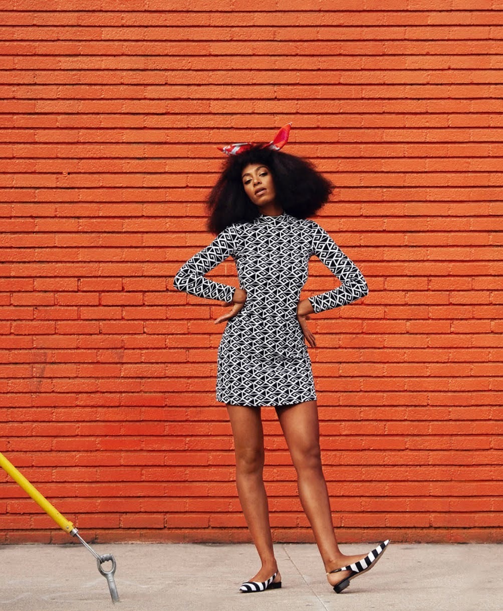 a woman standing in front of a brick wall