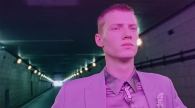 a man in a suit and tie standing in a tunnel