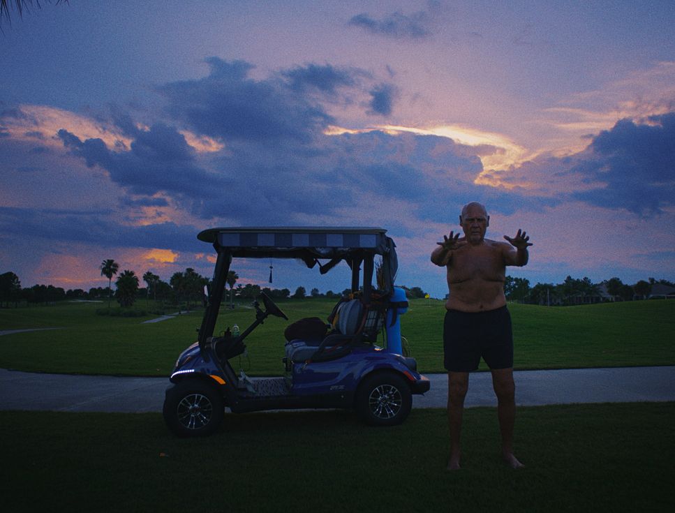 a man standing next to a golf cart