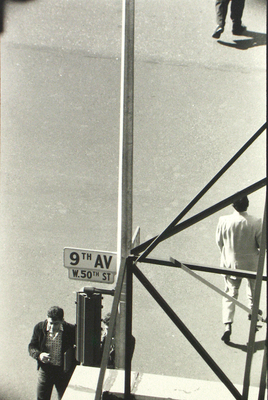 a black and white photo of a man walking down a street