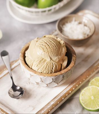 a bowl of ice cream with limes in the background