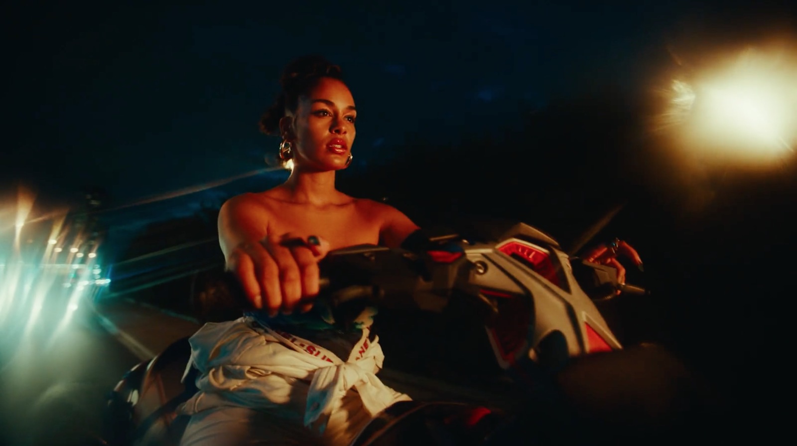 a woman sitting on a motorcycle in the dark