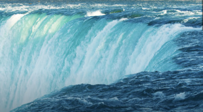 a large waterfall that is in the middle of a body of water