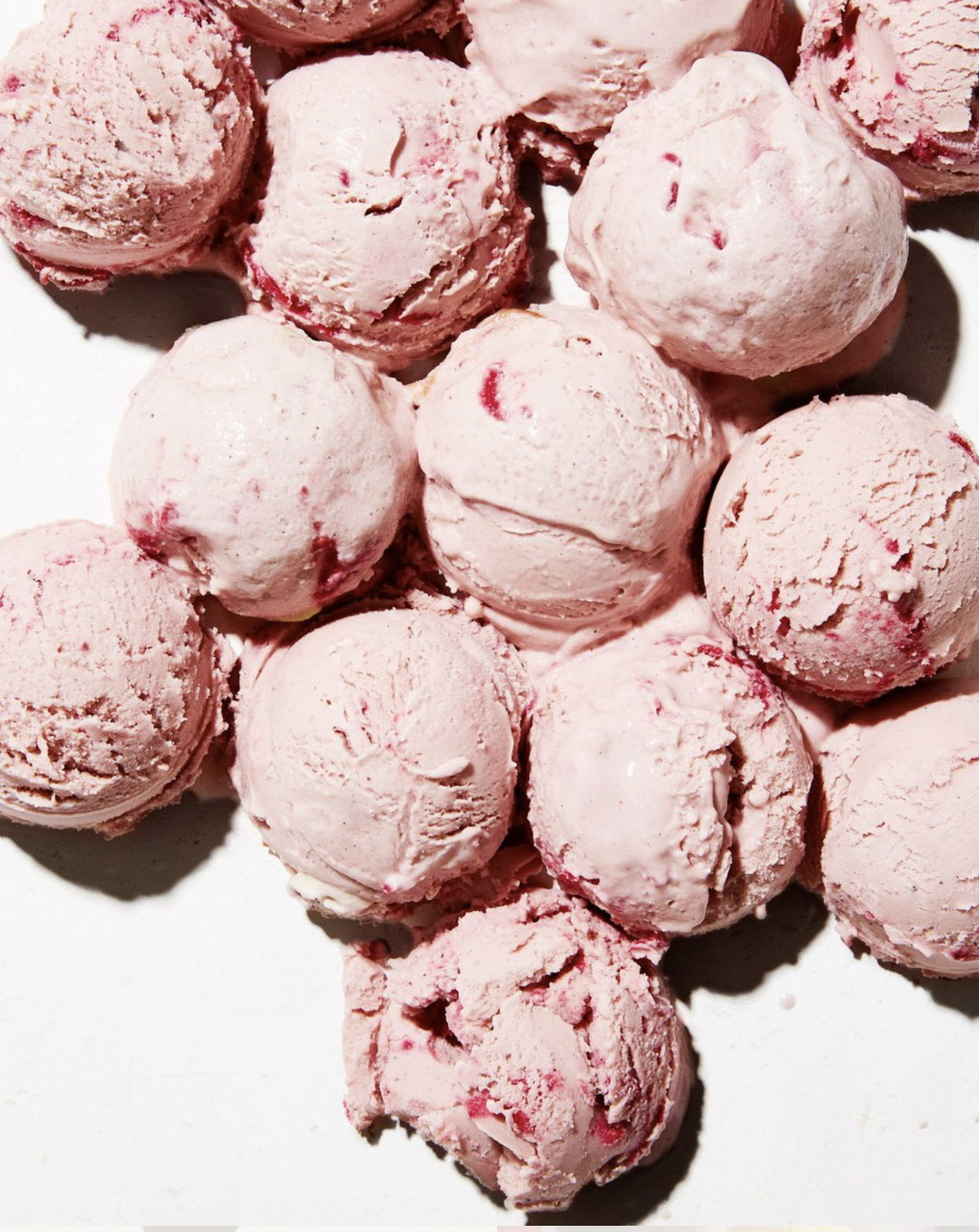 a pile of pink ice cream on a white surface