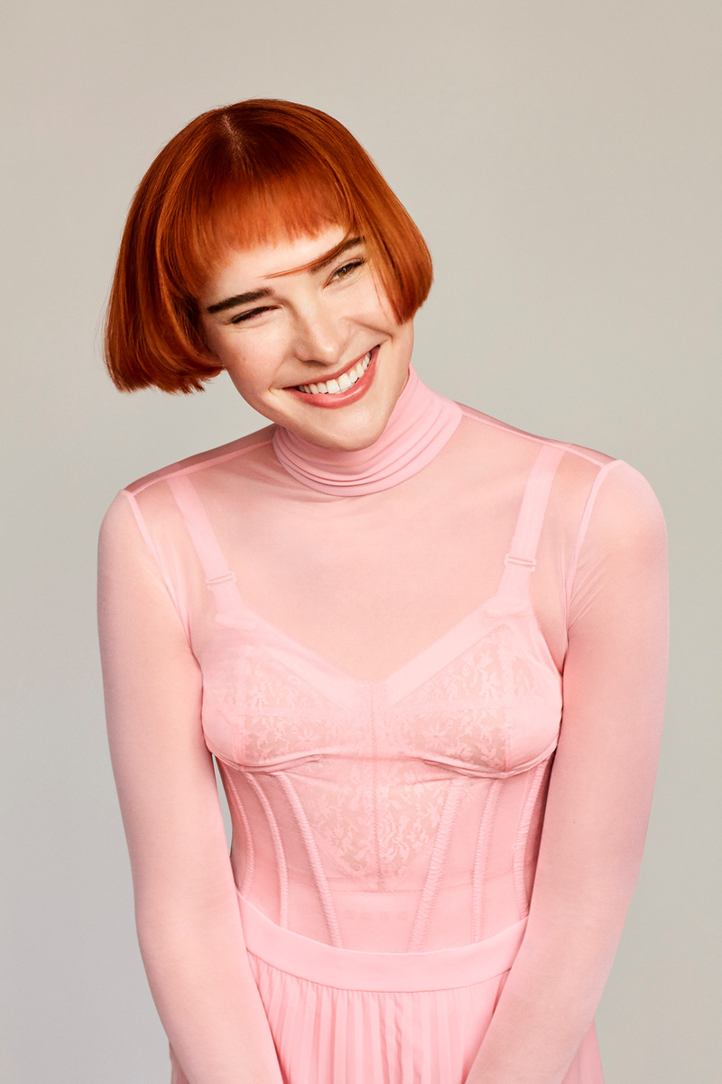 a woman with red hair wearing a pink dress