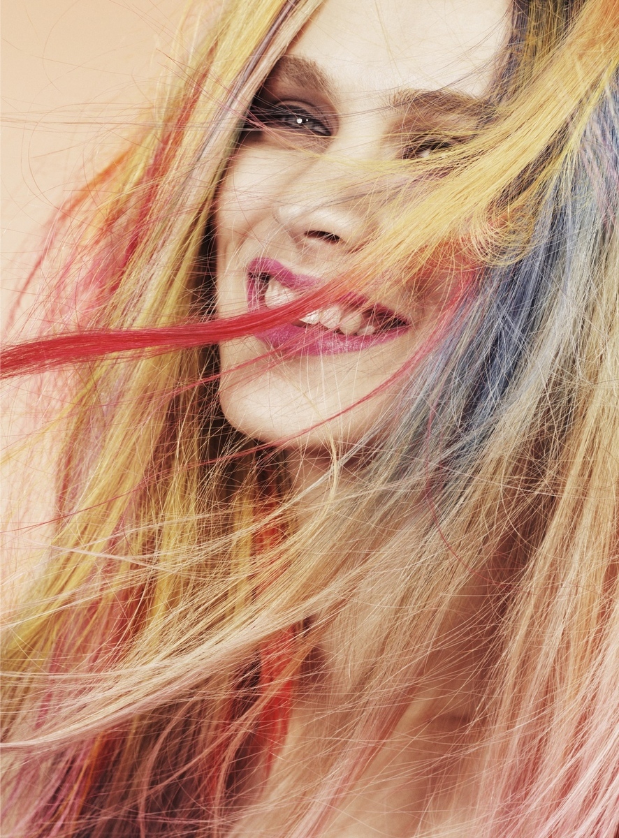 a woman with long blonde hair and red and blue streaks on her face