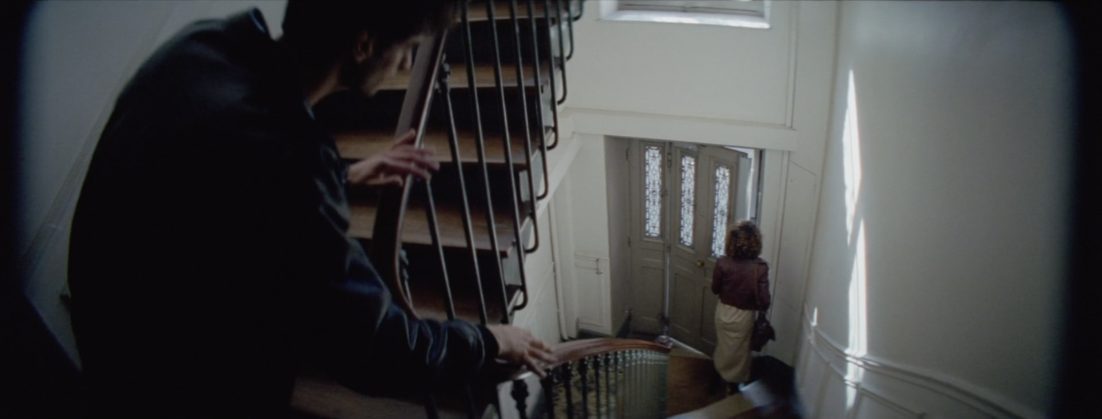 a man standing next to a stair case next to a window