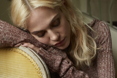 a woman is holding her head on a round cushion