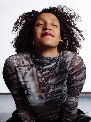 a woman with her eyes closed wearing large hoop earrings