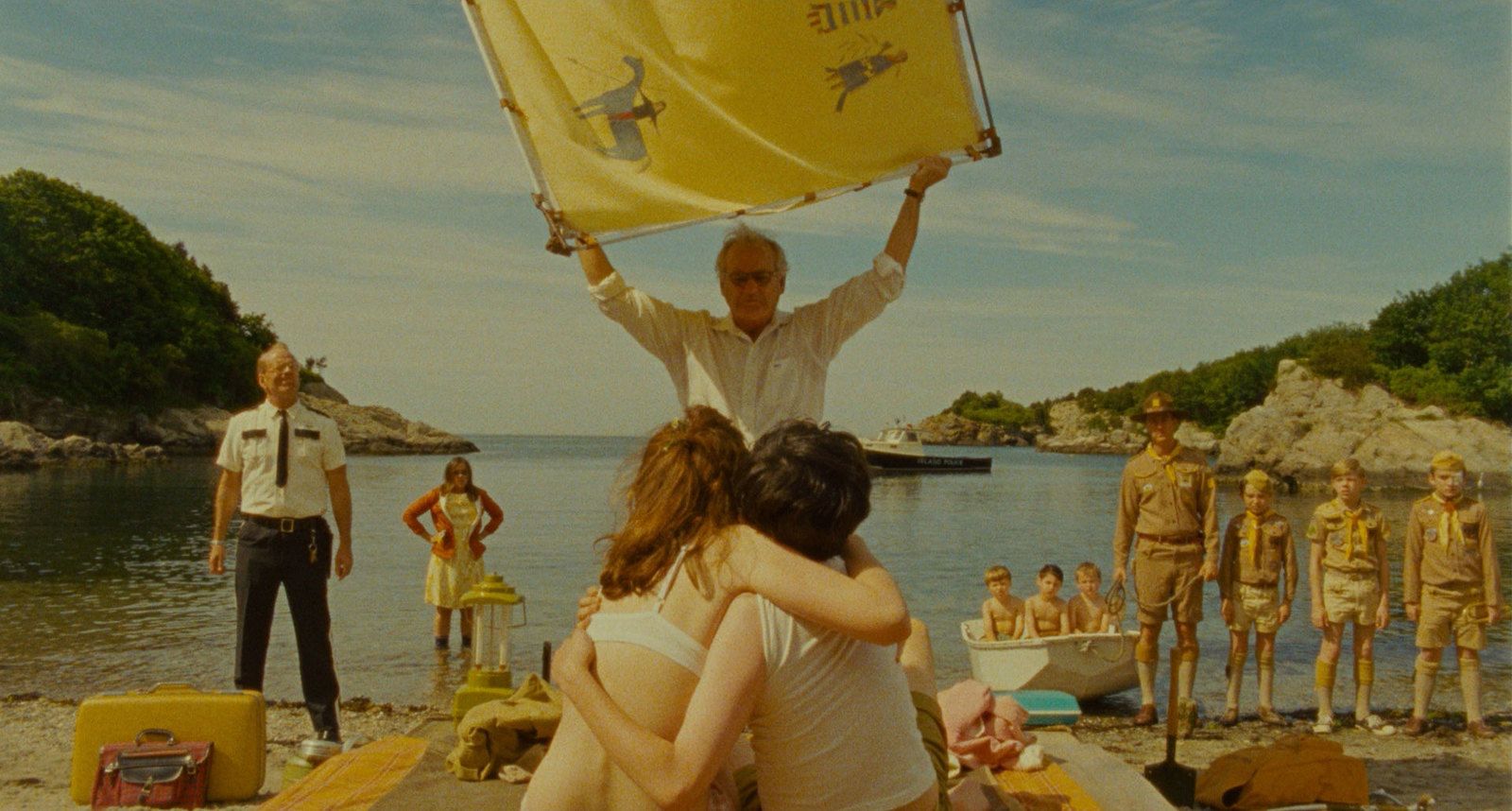 a group of people standing on a beach next to a body of water