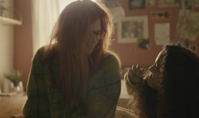 two women sitting on a couch talking to each other