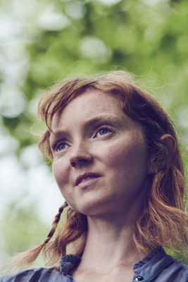 a close up of a person with a tree in the background