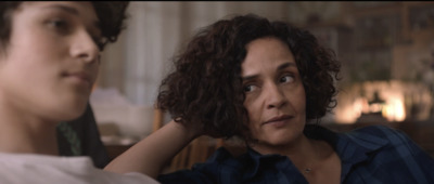 a woman with curly hair standing next to a man