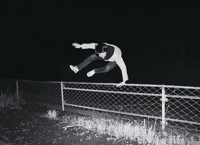 a person jumping a skate board over a fence