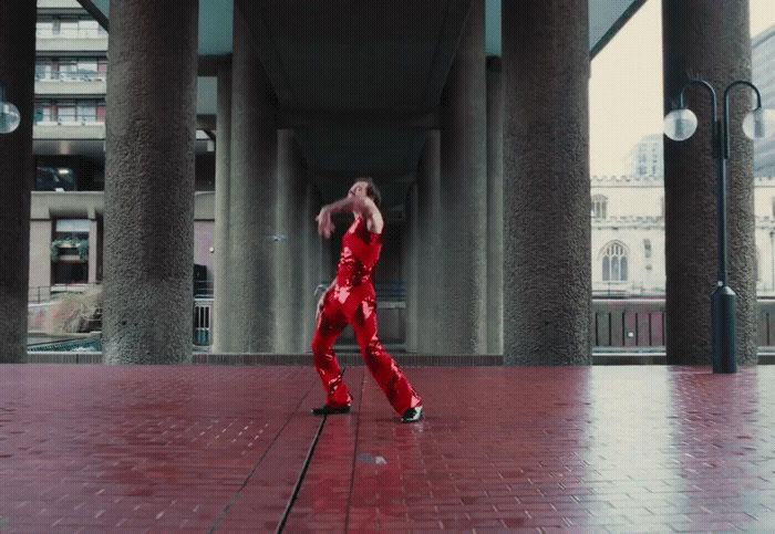 a man in red is dancing on a brick floor