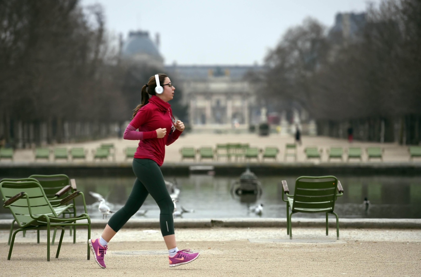 a woman running in a park near a pond