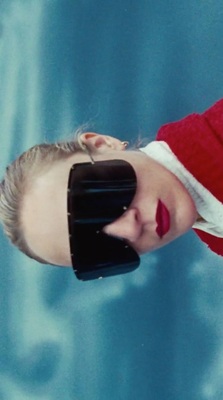 a woman in a red sweater with a blindfold on her face