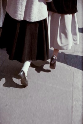 a group of people walking down a sidewalk