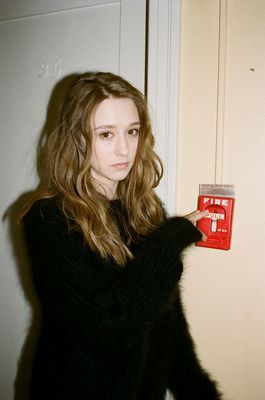 a woman holding a red box with a cross on it