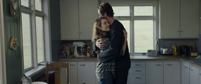 a man and a woman hug in a kitchen