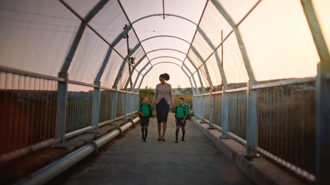 a woman and two children walking across a bridge